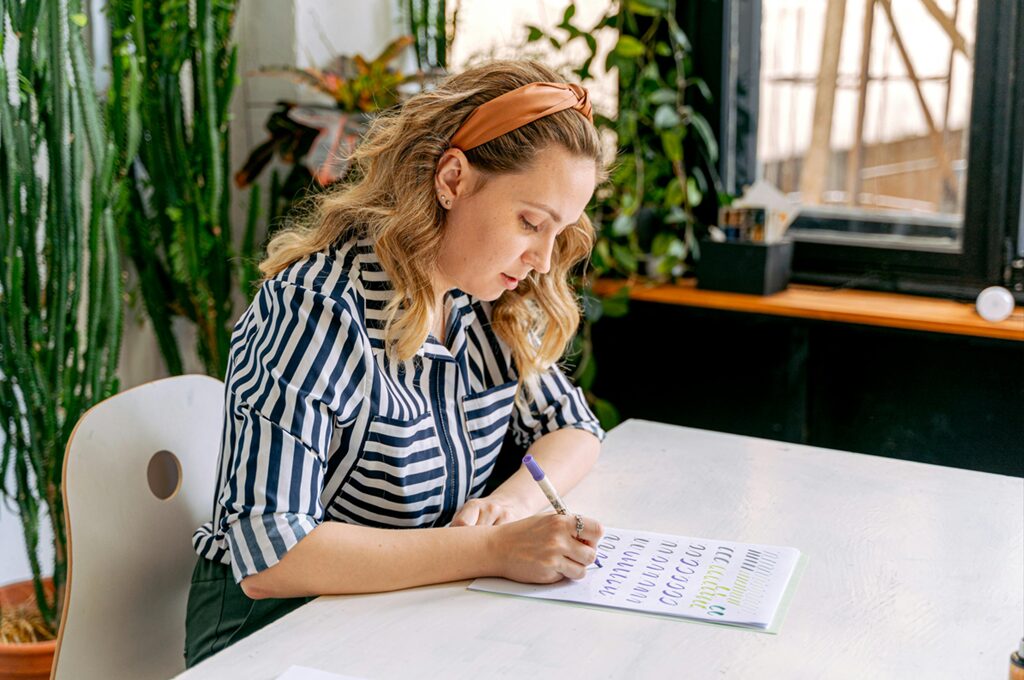 Person Practicing Handwriting with Guides